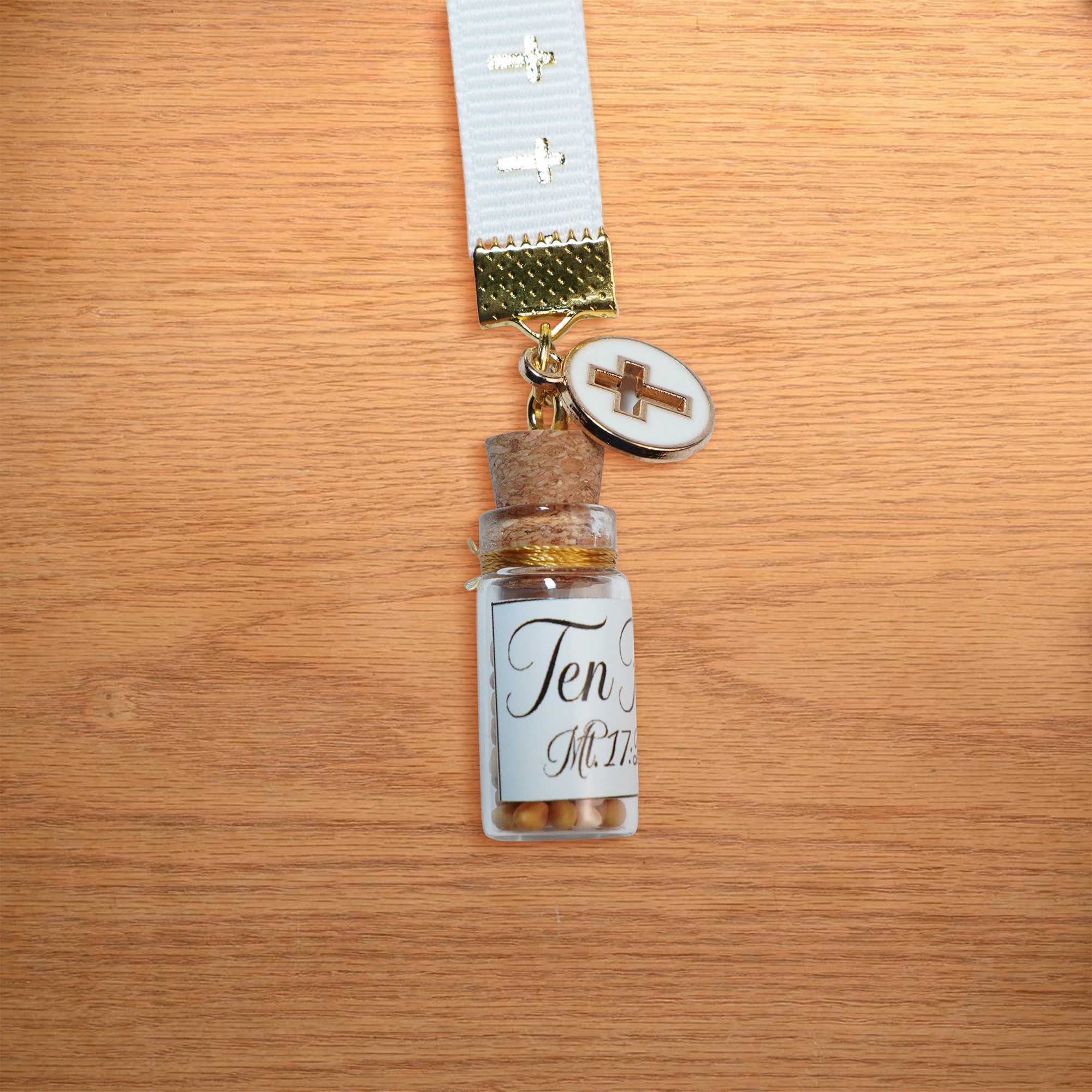 Separador de liston blanco con cruces doradas, borla, coldije y frasco con semillas de mostaza